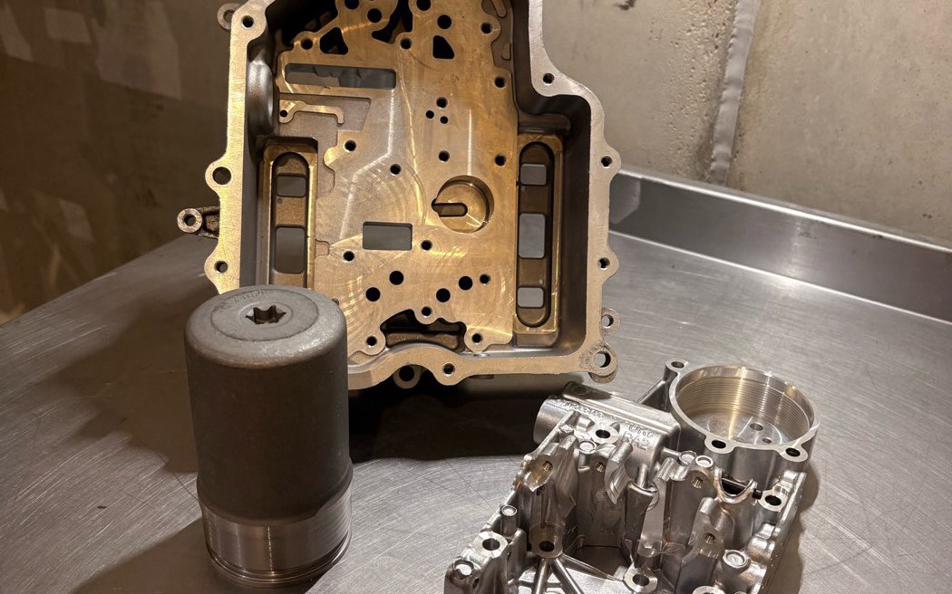 A DQ200 mechatronic stripped, with its accumulator stood alongside the valve body